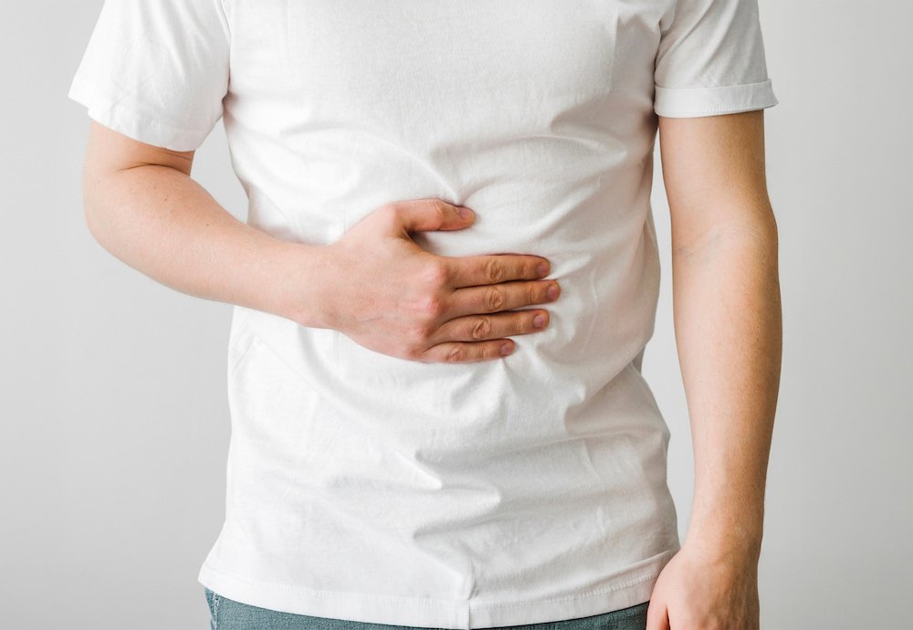 男士手按腹部表示腸胃不適,說明低乳糖希臘乳酪適合輕微乳糖不耐或飲奶易肚脹人士